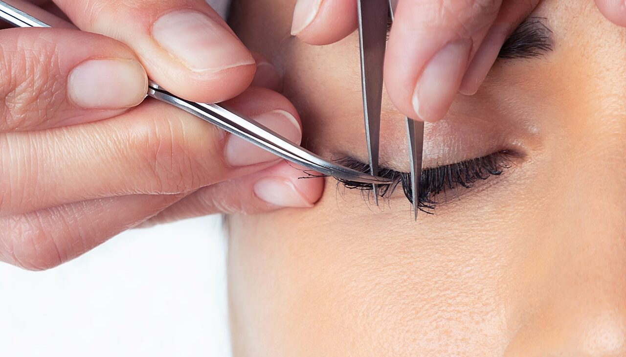 shot-cosmetologist-doing-eyelash-extension-procedure-woman-white-background